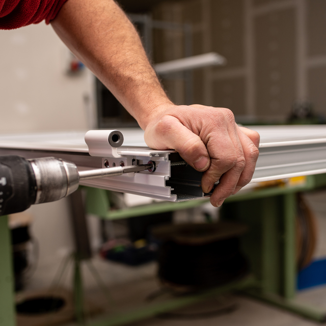 male-with-red-shirt-making-window-with-industrial-tools.jpg